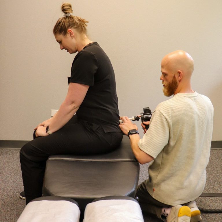Dr Kamryn using an Arthrostim to adjust the low back (lumabr spine)