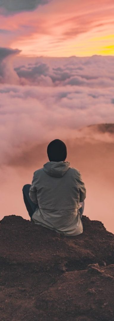 Man meditating overlooking mountains.